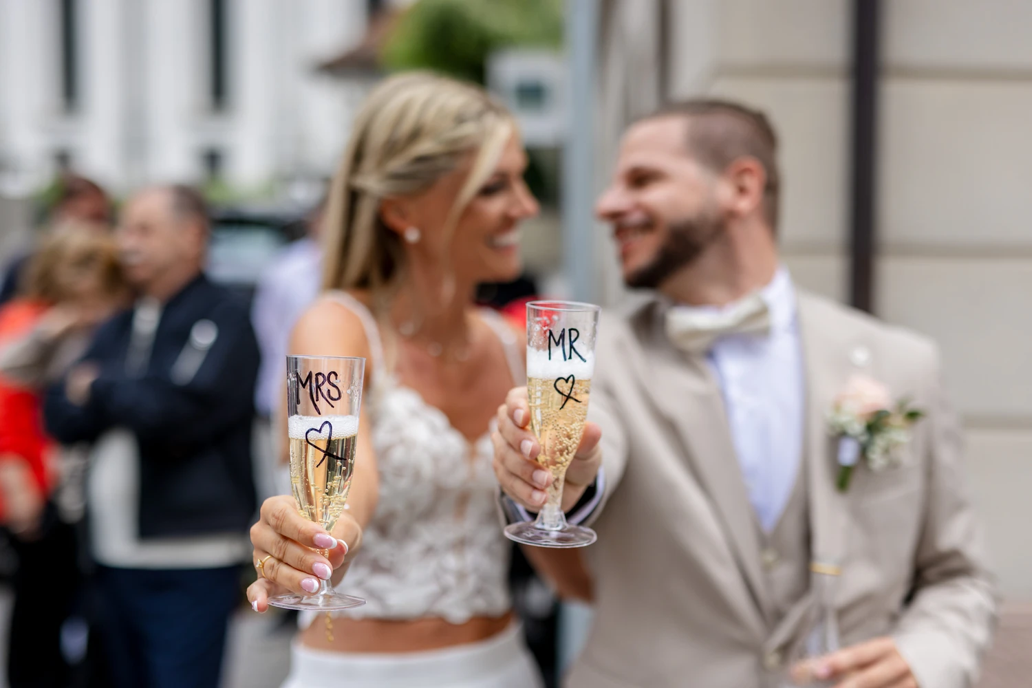 Brautpaar hält zwei Gläser mit dem Aufdruck MR und MRS in die Kamera