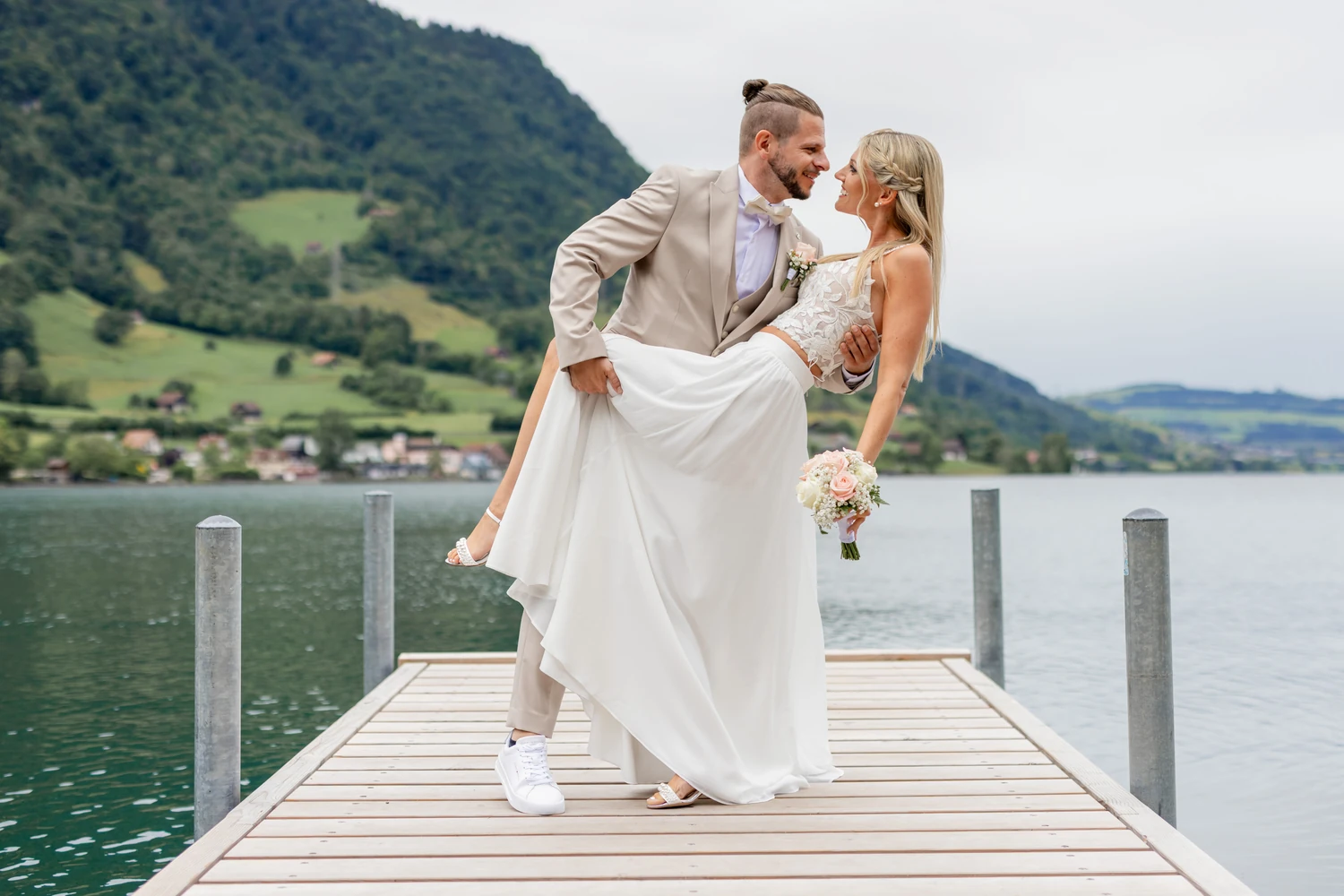 Brautpaar in einer tiefen Tanzfigur auf dem Steg im Zugersee, der Strauss in der Hand der Braut