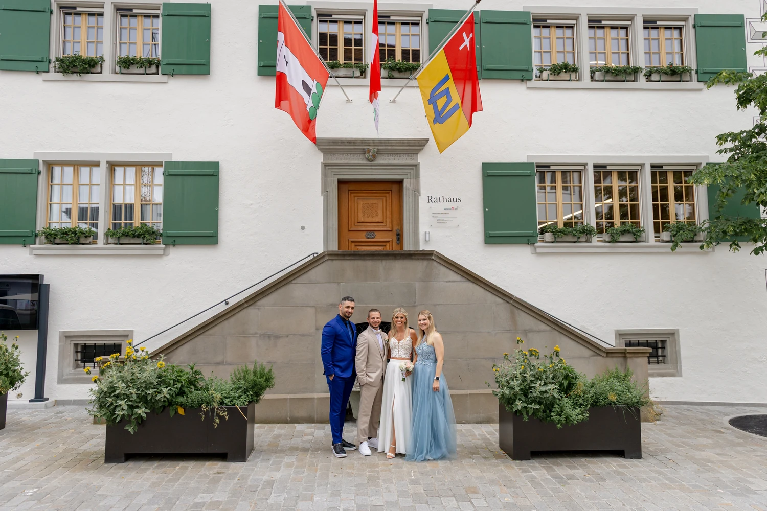 Das Rathaus Arth mit grünen Fensterläden, drei Fahnen über dem Portal und der doppelläufigen Freitreppe