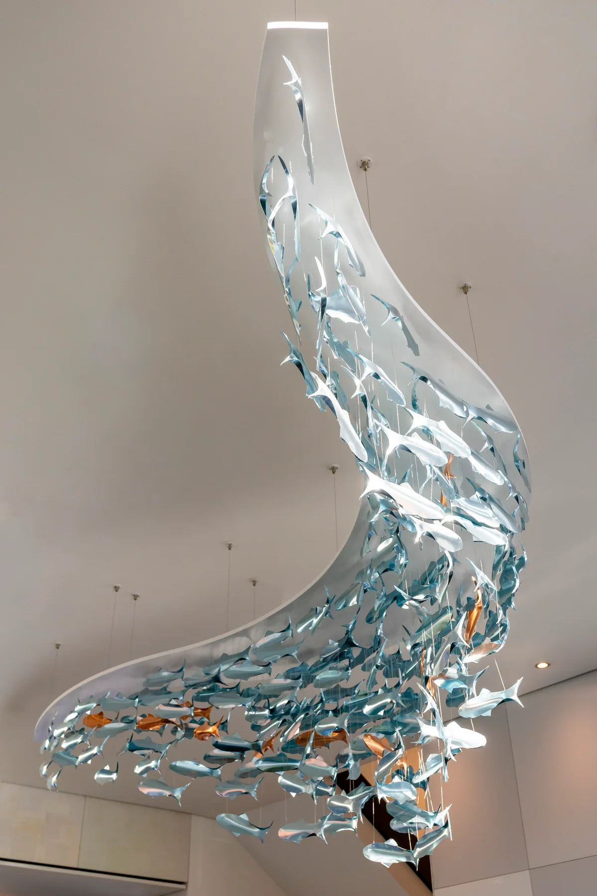 Glasskulptur aus vielen Fischen, die im Foyer des Hotels von der Decke hängt