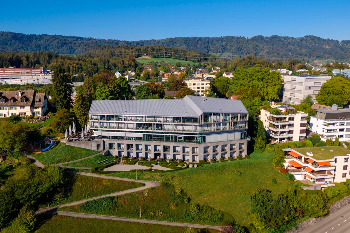 Luftaufnahme des Hotel Belvoir in Rüschlikon am Hang über dem Zürichsee