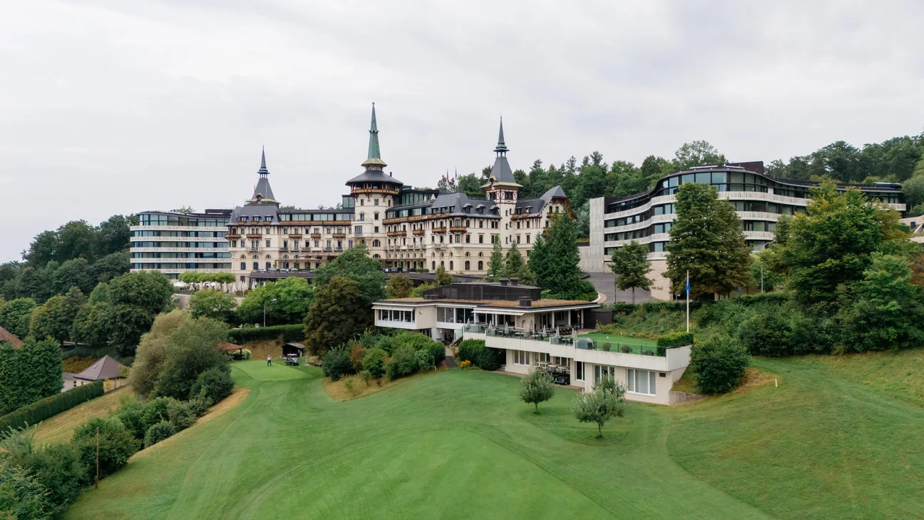 Das Dolder Grand in Zürich aus der Luft, davor die Wiese, ringsum Bäume