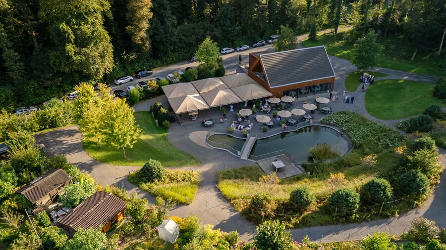 Der Heuboden in Holzhäusern von oben, mit Terrasse, Teich und Bäumen