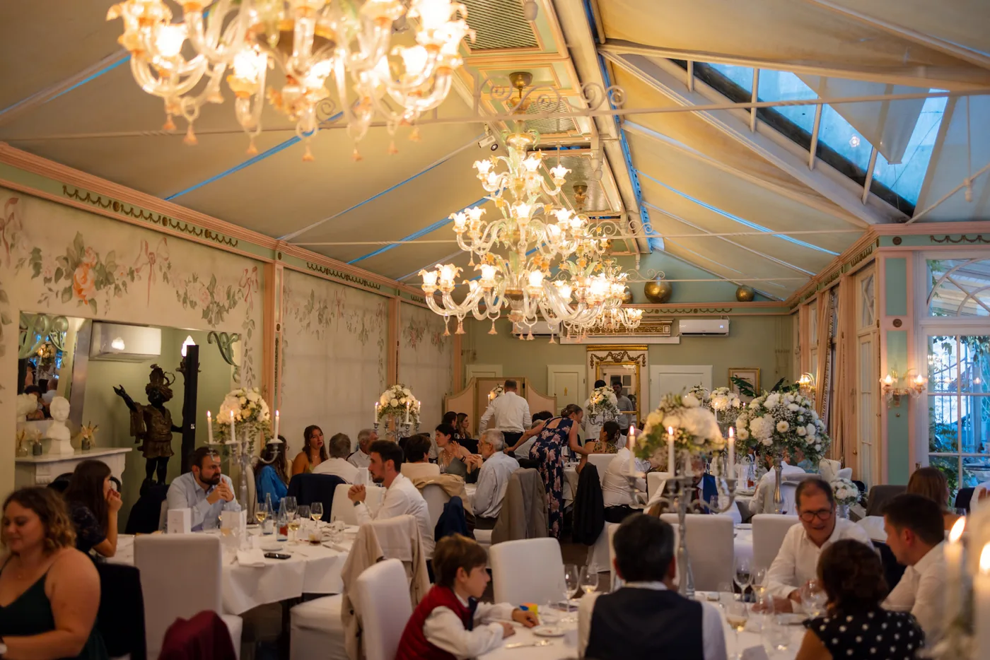 Der Wintergarten am Abend, Kronleuchter und Kerzen auf den Tischen