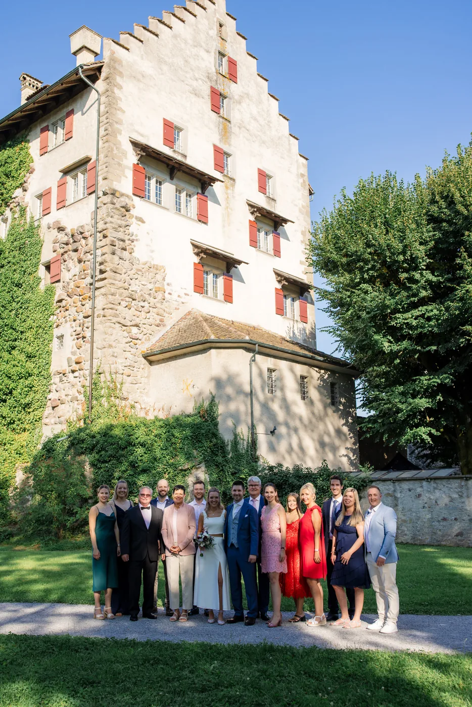 Die ganze Hochzeitsgesellschaft steht im Schlossgarten vor dem Schloss Greifensee