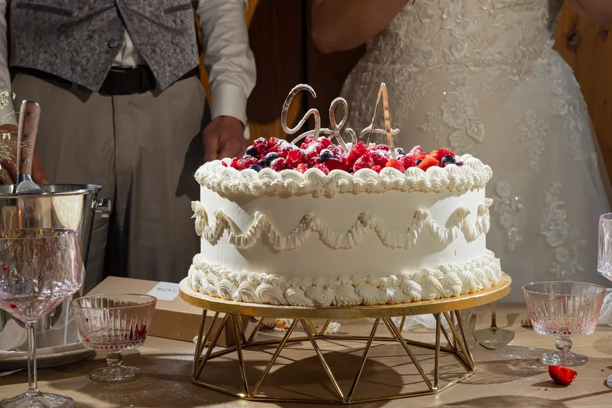Die fertige Torte aus der Nähe, oben Beeren, dazwischen ein Aufsatz aus zwei Initialen
