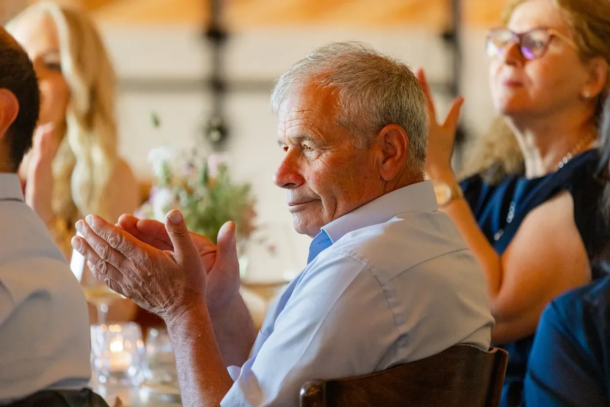 Gäste applaudieren an der langen Tafel
