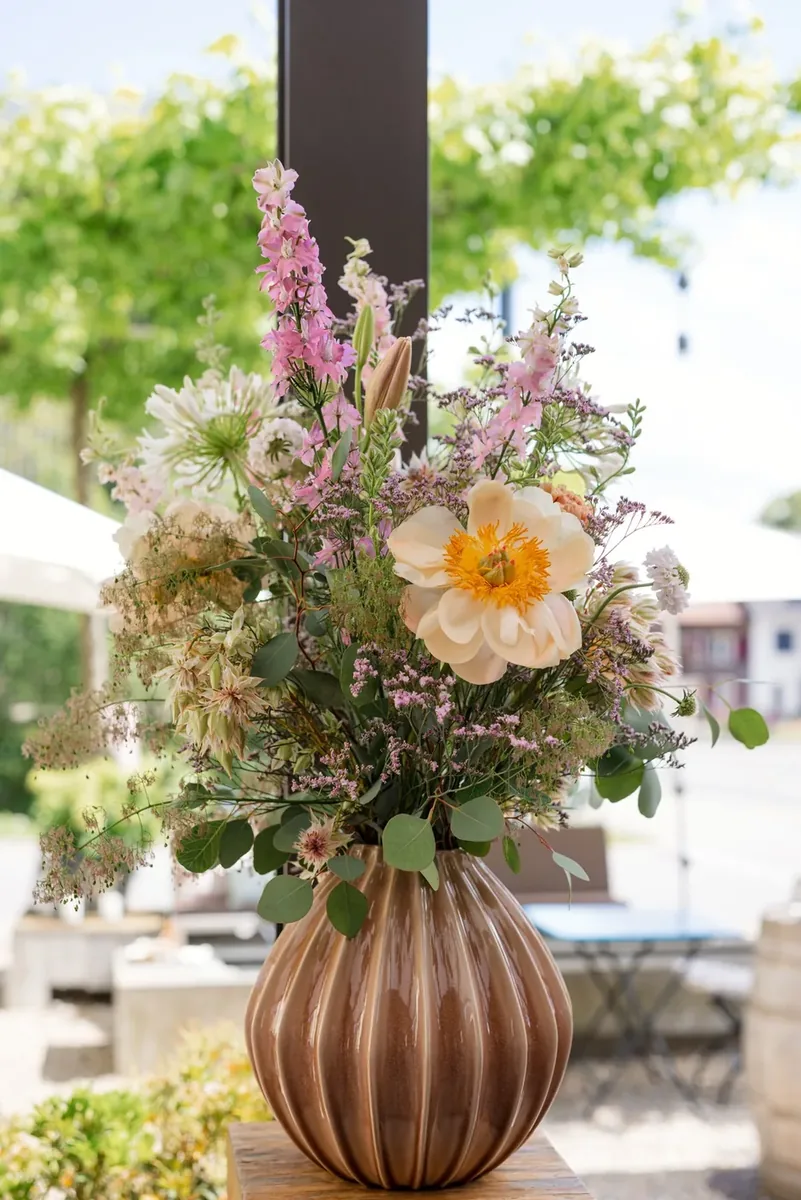 Grosser Blumenstrauss in einer geriffelten Vase auf der Terrasse