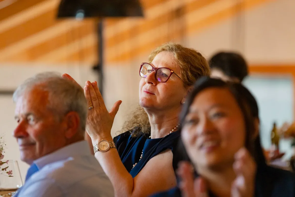 Zwei Gäste applaudieren, im Hintergrund die Tafel
