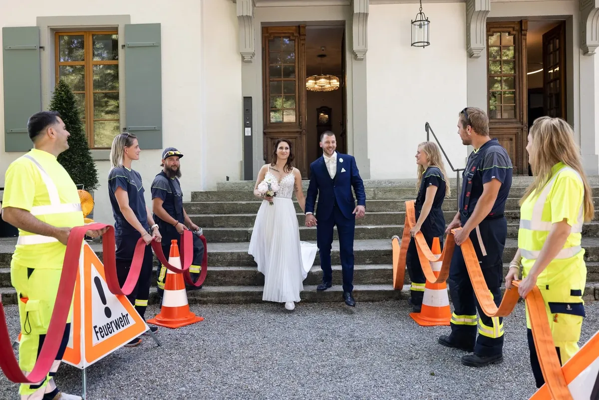 Das Brautpaar zwischen den Feuerwehrleuten vor dem Schloss