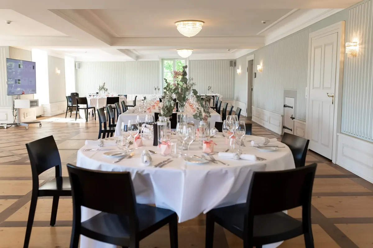 Der Schloss Saal mit rundem Tisch im Vordergrund und Langtafeln dahinter