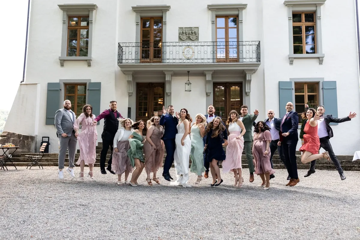Die Gesellschaft springt und lacht vor dem Schloss