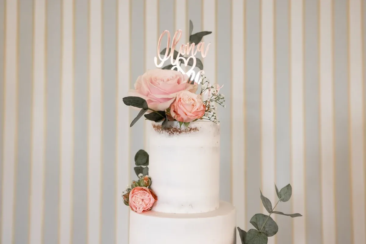 Die Hochzeitstorte aus der Nähe mit Rosen und Eukalyptus