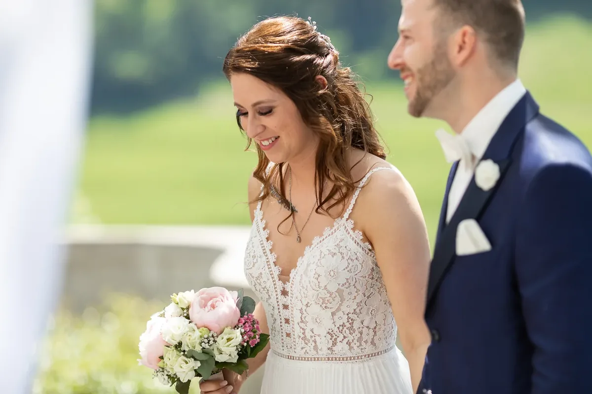 Nahaufnahme der lächelnden Braut mit rosa-weissem Brautstrauss