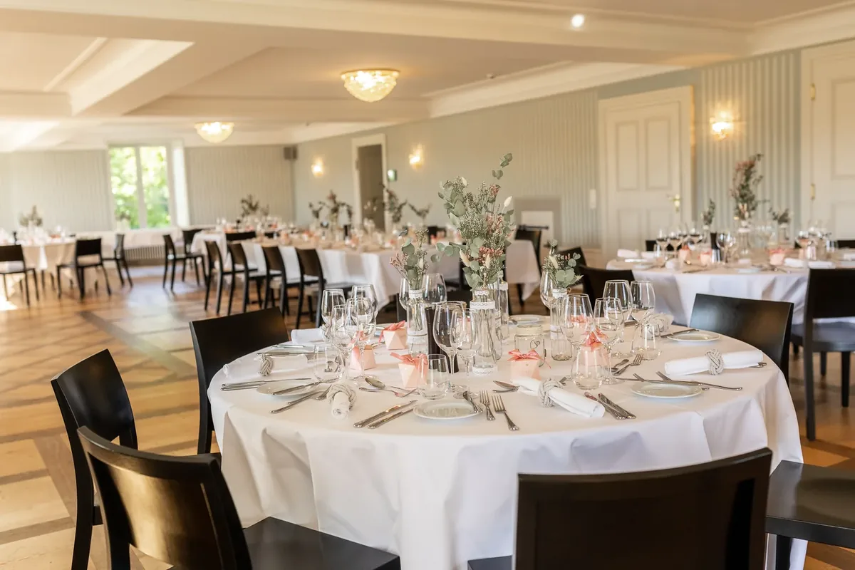 Runder gedeckter Tisch mit Trockenblumen im Schloss Saal