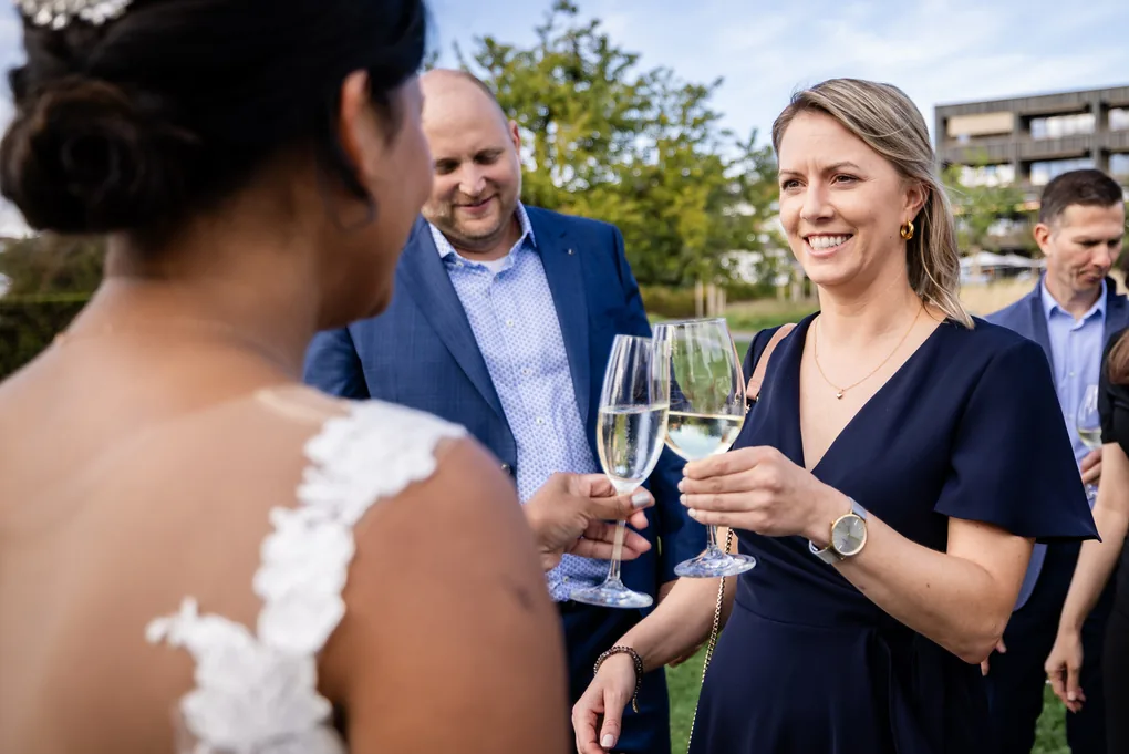 Gast stösst mit der Braut mit Champagnergläsern an