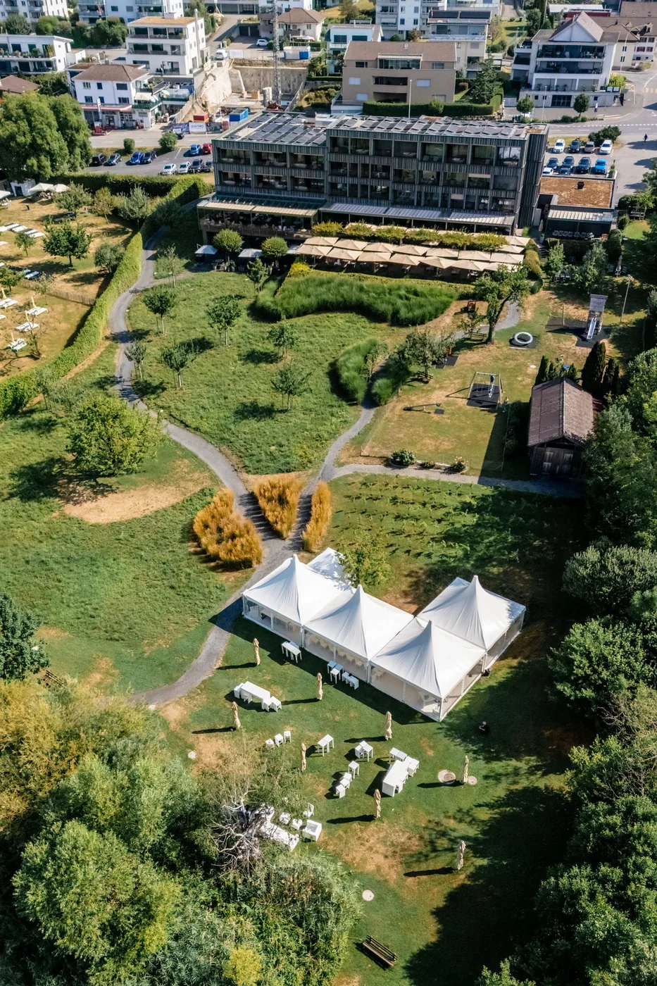 Luftaufnahme über den Sempachersee mit dem Hotel am Ufer und dem Dorf dahinter