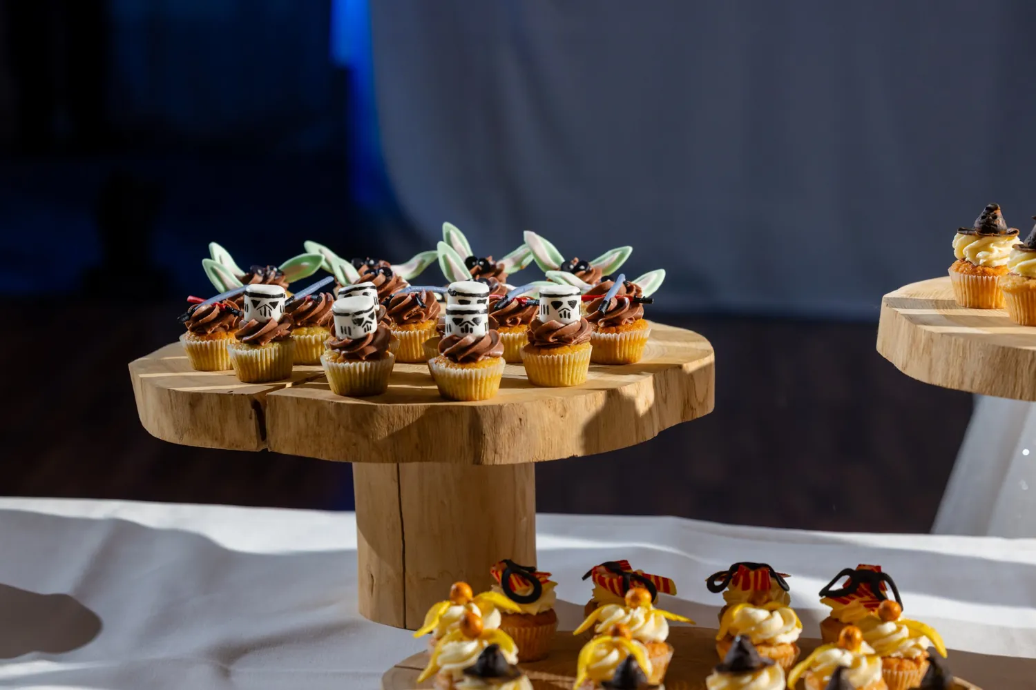 Mini-Cupcakes mit verspielter Deko auf Etageren aus Holz