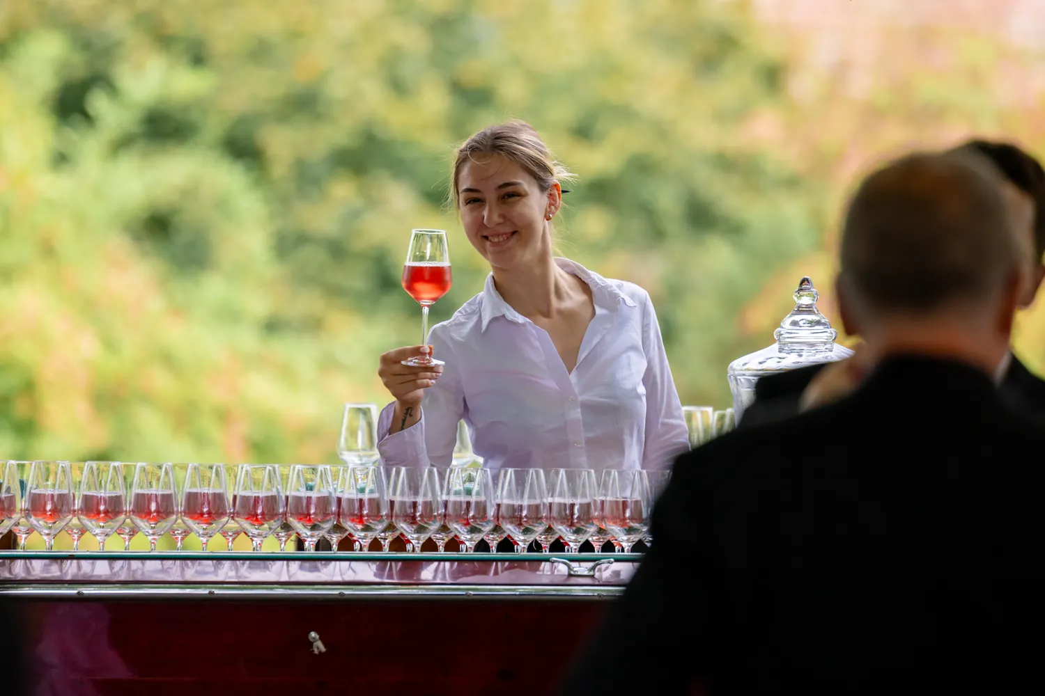 Spritz-Bar mit langen Reihen roter Gläser beim Apéro