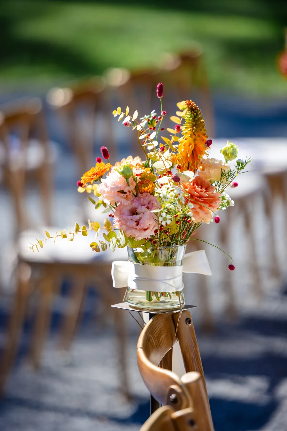 Wildblumen im Glas an einem Stuhl der freien Trauung