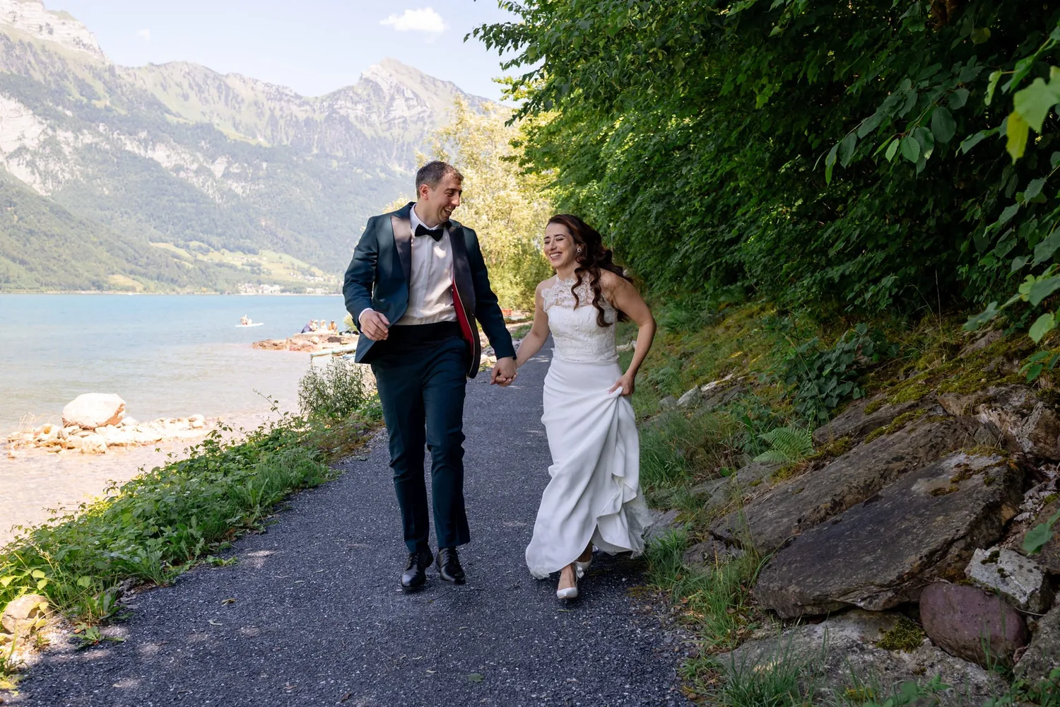 Brautpaar geht Hand in Hand einen Uferweg am Walensee entlang
