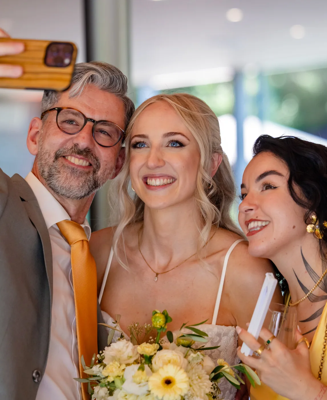 Braut macht beim Apéro ein Selfie mit zwei Gästen