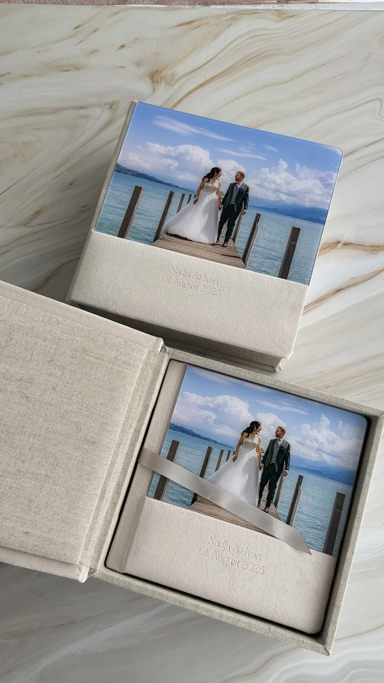 Zwei Hochzeitsalben mit Acrylglas-Cover in Leinenboxen, auf dem Bezug die geprägten Namen und das Hochzeitsdatum
