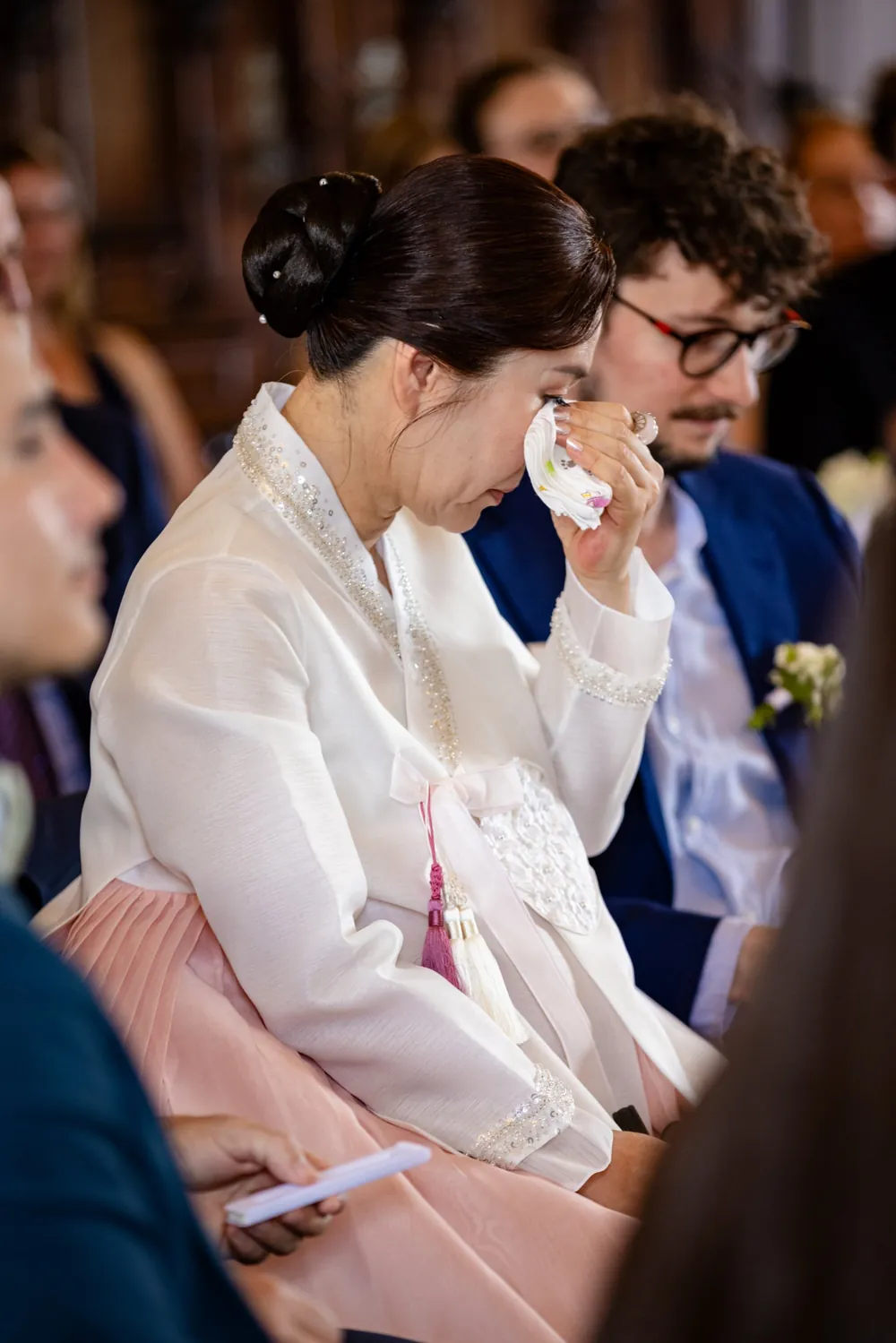 Eine Frau im koreanischen Hanbok wischt sich während der Trauung eine Träne ab